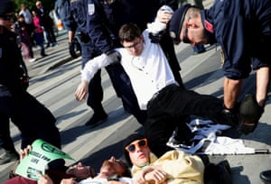 Police officers pick up an activist