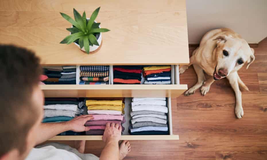 High angle view of man organising clothing drawer at home