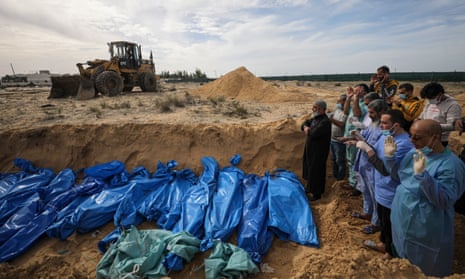 Palestinians pray next to the bodies of 111 unidentified people killed in Israeli strikes on Gaza, during their burial in a mass grave in Khan Younis.