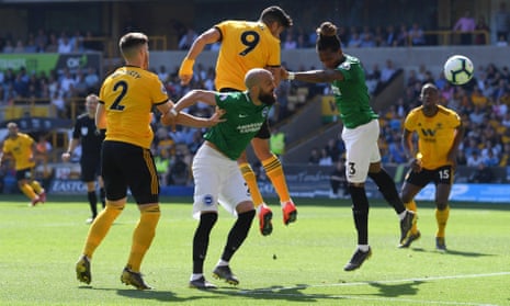 Raul Jimenez of Wolverhampton Wanderers heads wide under pressure from Gaetan Bong of Brighton.