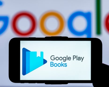 A smartphone displays the Google Play Books logo in front of a blurred Google logo