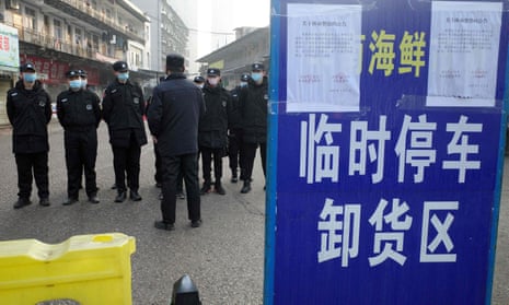 Security guards standing in front of the closed Huanan wholesale seafood market, where health authorities say a man who died from a respiratory illness had purchased goods from, in the city of Wuhan, Hubei province.