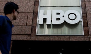 a man looking at the HBO sign on the side of a building
