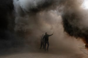 Beirut, Lebanon. Protesters surrounded by smoke from burning tyres rally against the Lebanese Central Bank governor Riad Salameh and the deepening financial crisis