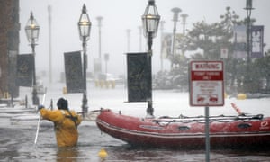 A firefighter wades through waters from Boston Harbor, which flooded onto Long Wharf on 4 January 2018.