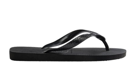 A black flip flop, pointing to the right. It is on a white background.