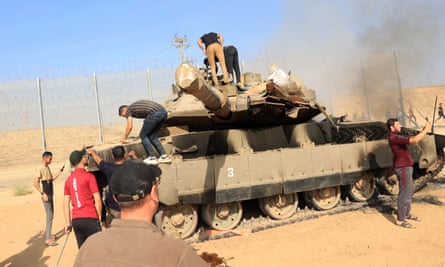 Palestinians take control of an Israeli tank after crossing the border fence with Israel from Khan Yunis in the southern Gaza Strip on Saturday.