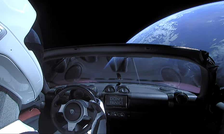 A cherry red Tesla Roadster automobile floats through space after it was carried there by SpaceX’s Falcon Heavy.
