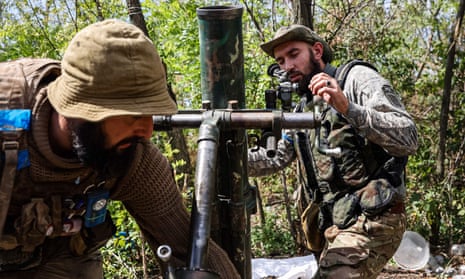 Ukrainian volunteer fighters prepare a mortar launcher in the Donetsk region 
