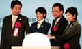 Shinzo Abe and other dignitaries launch construction of the stadium by putting their hands on a rotating globe.