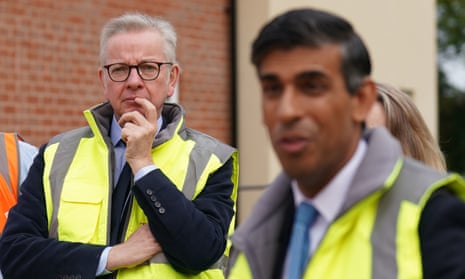Prime minister Rishi Sunak and Michael Gove, Minister for Levelling Up, Housing and Communities, wearing hi-vis jackets and talking to people during a visit to the Taylor Wimpey Heather Gardens housing development in Norwich.