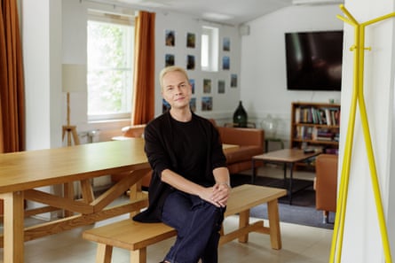 Man with black jumper and short blond hair sitting at a dining table