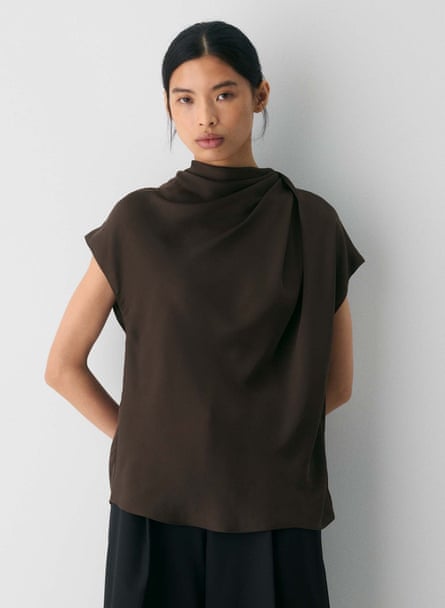woman wearing brown oversized shirt with hands behind back