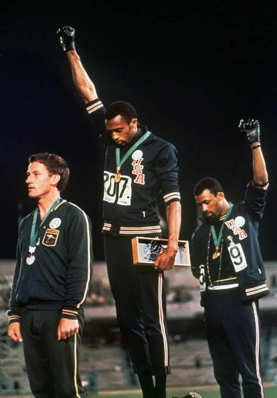 Extending gloved hands skyward in Black Power protest, U.S. athletes Tommie Smith, center, and John Carlos stare downward during the playing of the Star Spangled Banner after Smith received the gold and Carlos the bronze for the 200 meter run at the Summer Olympic Games in Mexico City on Oct. 16, 1968. Australian silver medalist Peter Norman is at left
