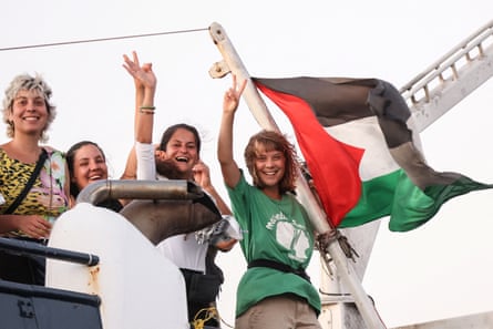 Greta Thunberg and a crew member flash victory signs from their ship, part of the Global Sumud Flotilla aiming to reach Gaza, last week.
