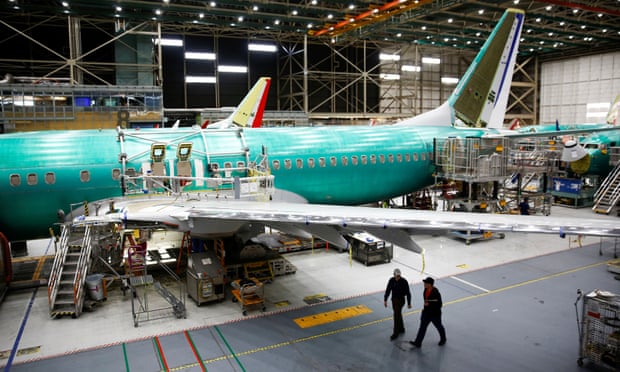 Two workers walk under the wing of a 737 Max aircraft at the Boeing factory in Washington