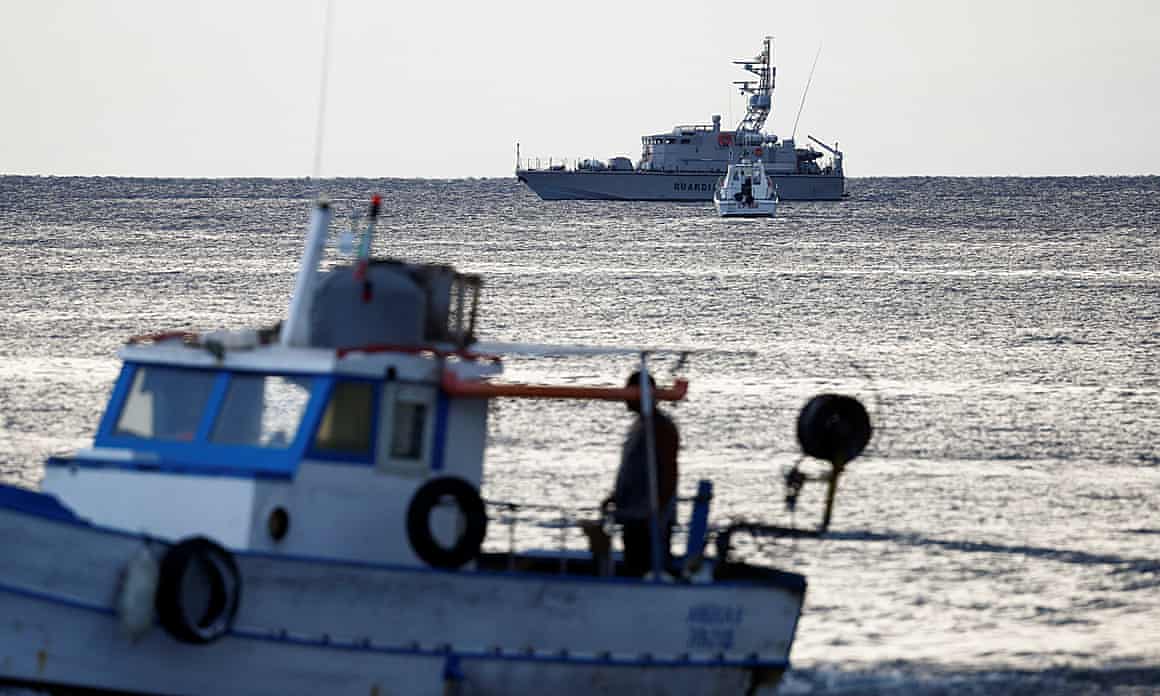 A fishing boat sails past a police vessel and a coastguard vessel