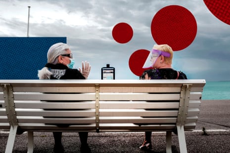 Women chat while sitting on a bench at the Promenade des Anglais in Nice, southern France