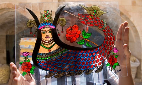 An artist holding a Shahmaran, a mythical creature that is half woman, half snake