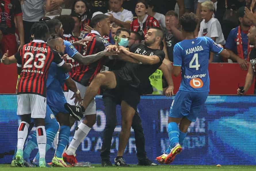 Fans and players fight on the side of the pitch at the Allianz Riviera in Nice.
