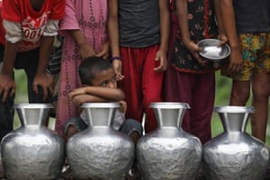 Sylhet, Bangladesh. Children wait in a line after travelling a long distance to collect safe drinking water in a flooded area
