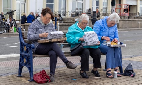Three women eating fish and chips in Porthcawl, Wales, in April as Covid rules were eased to allow six people to meet up outside.