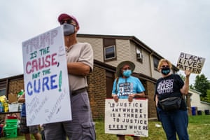 Demonstrators hold signs at the site where Jacob Blake was shot by police in Kenosha, Wisconsin.