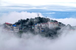 A hilltop town with clouds just below it on all sides