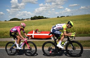 Intermarché-Wanty-Gobert Matériaux team’s Norwegian rider Sven Erik Bystrøm (right) and EF Education-Easypost’s Danish rider Magnus Cort Nielsen cycle past a spectator riding in a custom vehicle painted in Danish national colours