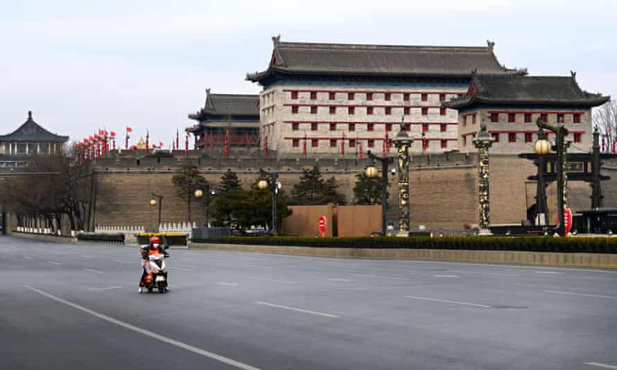 Um motorista de entrega em uma rua vazia perto do portão de Yongning em Xi'an, que está trancado há seis dias.