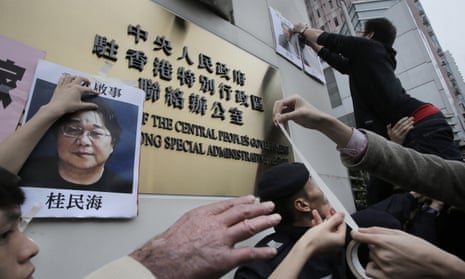 Protesters attach photos of missing booksellers outside the Liaison of the Central People’s Government in Hong Kong.