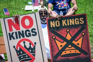 people hold signs that read ‘no kings’