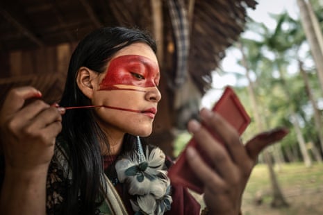 Bianca, a younger member of the Ashaninka, paints her face.
