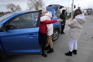 A woman hugs another woman upon her arrival at the border crossing in Medyka