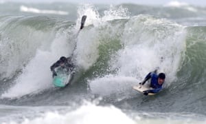 Body boarders ride the stormy waves at Broad Haven, Pembrokeshire.