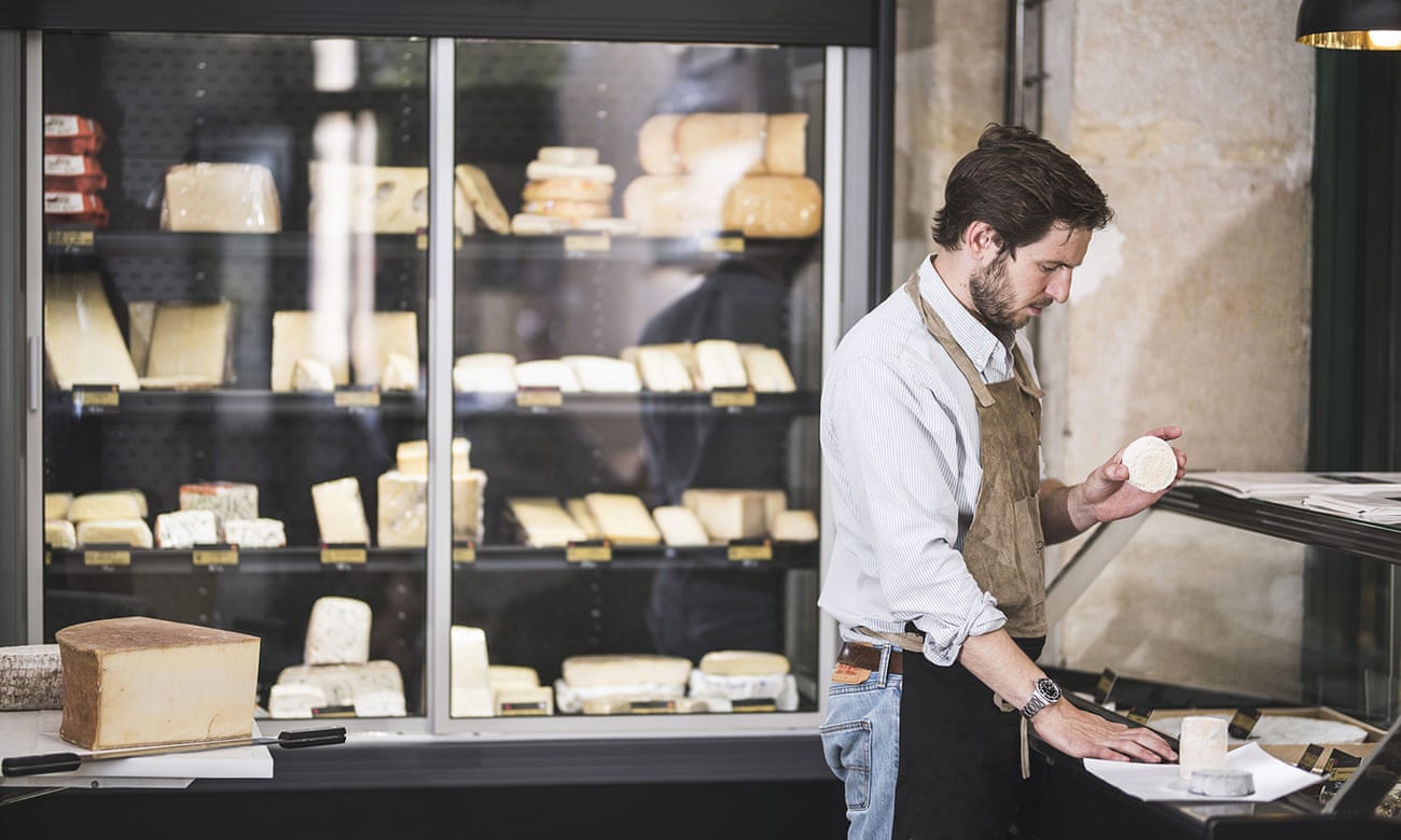 In the Batignolles, the fromagerie Formaticus has a loyal following for its cheeses and sharing platters. In this image a shopworkers wraps cheese for a customer.