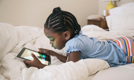 Girl using digital tablet in a bed