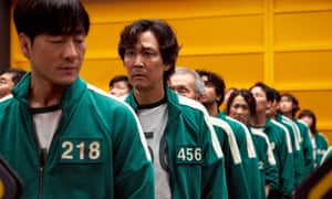 Cast of Squid Game standing in line in tracksuits