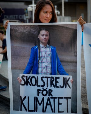 An activist holds a sign with Greta Thunberg’s photo during a climate strike
