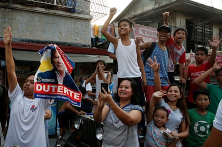 Supporters watch a Duterte motorcade during election campaigning in Malabon, Metro Manila, in 2016