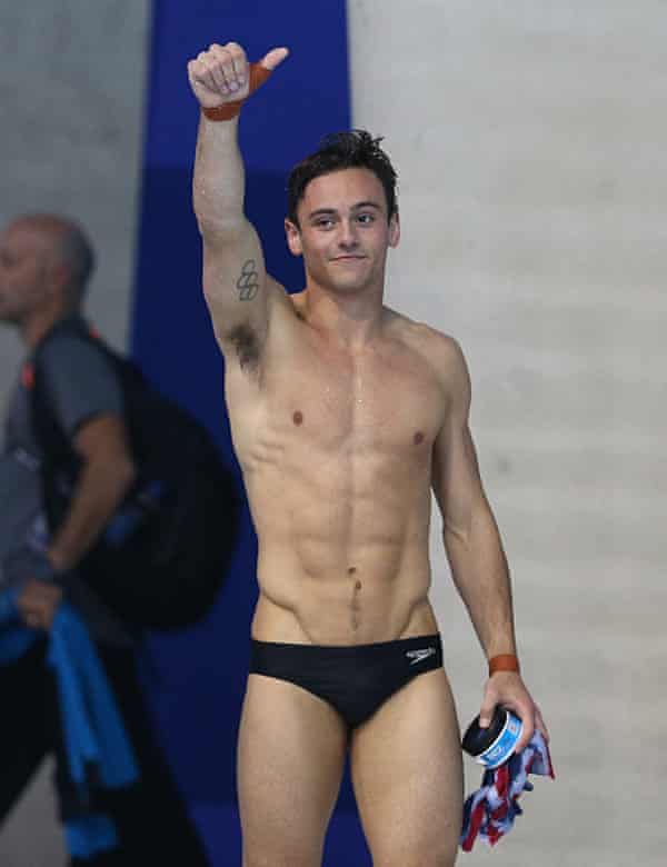 Tom Daley em Speedos dando um polegar para cima