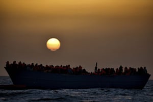 A full boat waits to be rescued adrift at sunset yesterday