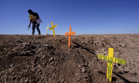Hugo Castro leaves crosses at the scene of a deadly crash in Holtville, California.