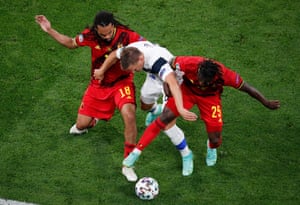 Robin Lod of Finland battles for possession with Jason Denayer and Jeremy Doku of Belgium.