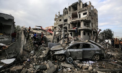 Palestinians search through building rubble for survivors after Israeli strikes in Maghazi, central Gaza, on Christmas Day