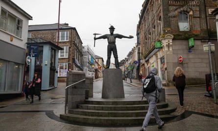 A sculpture of a tin miner on a high street.