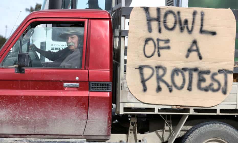 a farmer drives by with a 'howl of a protest' sign in new zealand