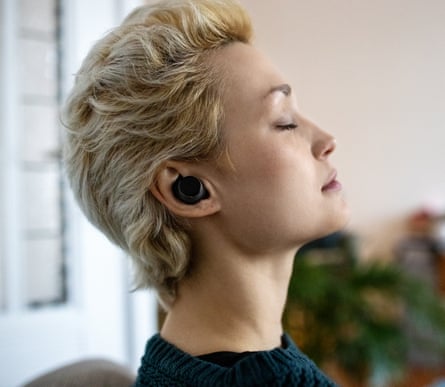 Side position of a young female wearing wireless earphones, relaxing