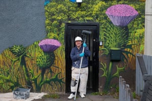 Robin Rankin paints over a mural of thistles and Loch Lomond at Balloch.