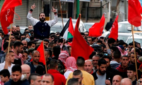 Members of the Popular Front for the Liberation of Palestine wave the group’s flag during Sajid Muzher’s funeral.